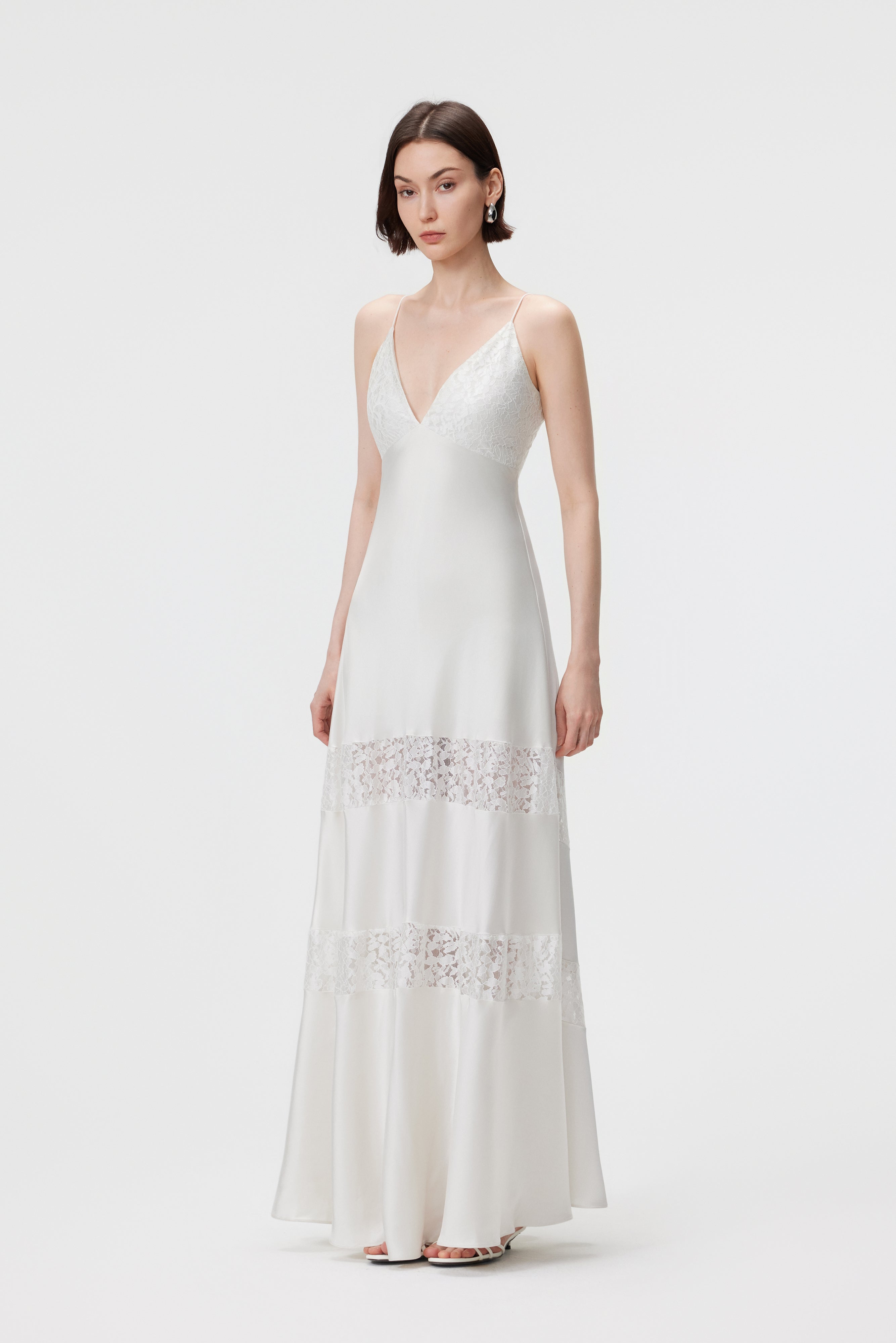 Side profile of the Kaia dress in Pearl, showcasing the seamless bias-cut fit and the rhythmic movement of the liquid-satin fabric and artisanal lace.