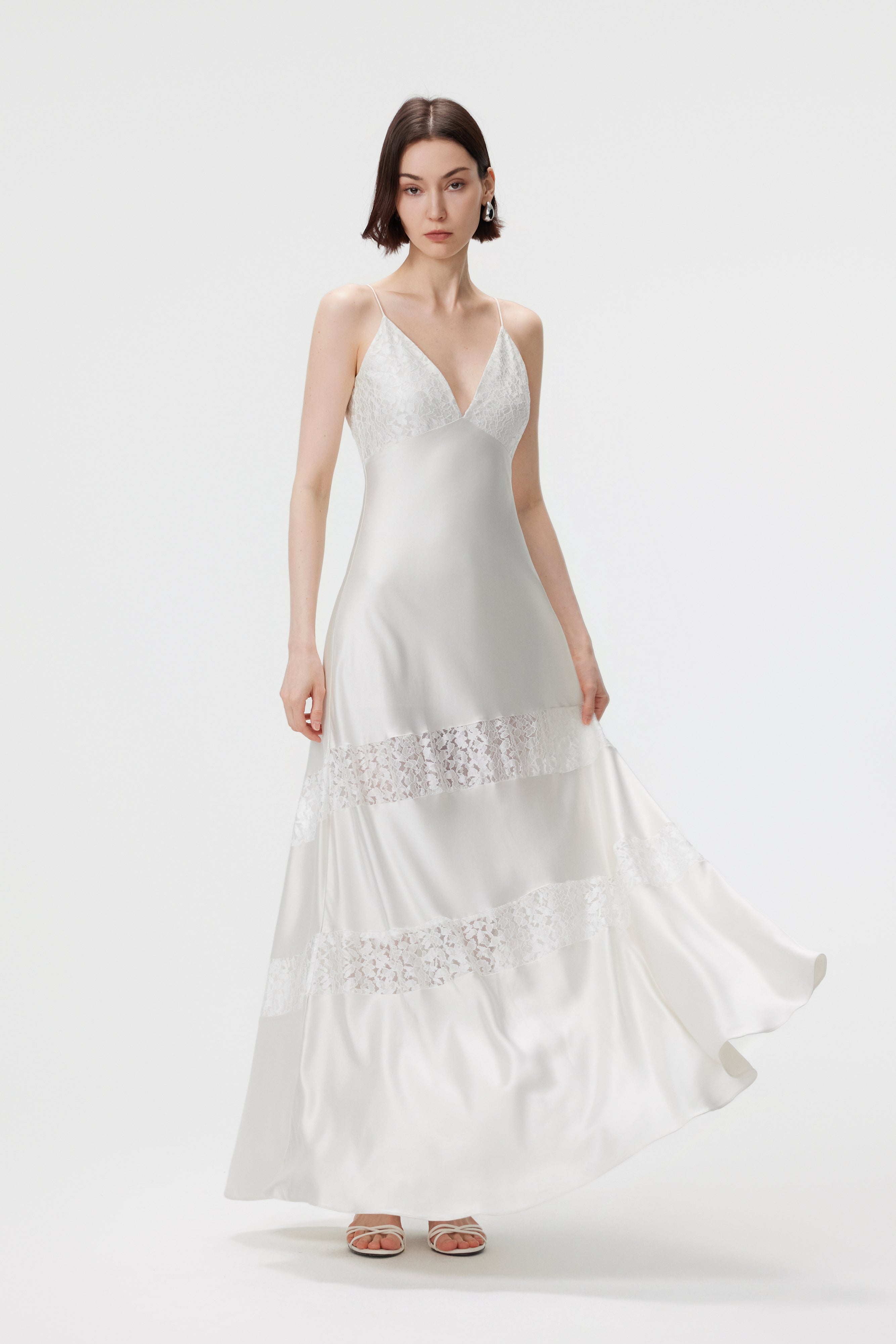 The AENSO Kaia dress in motion; demonstrating the liquid fluidity and rhythmic drape of the bias-cut pearl satin and delicate lace.