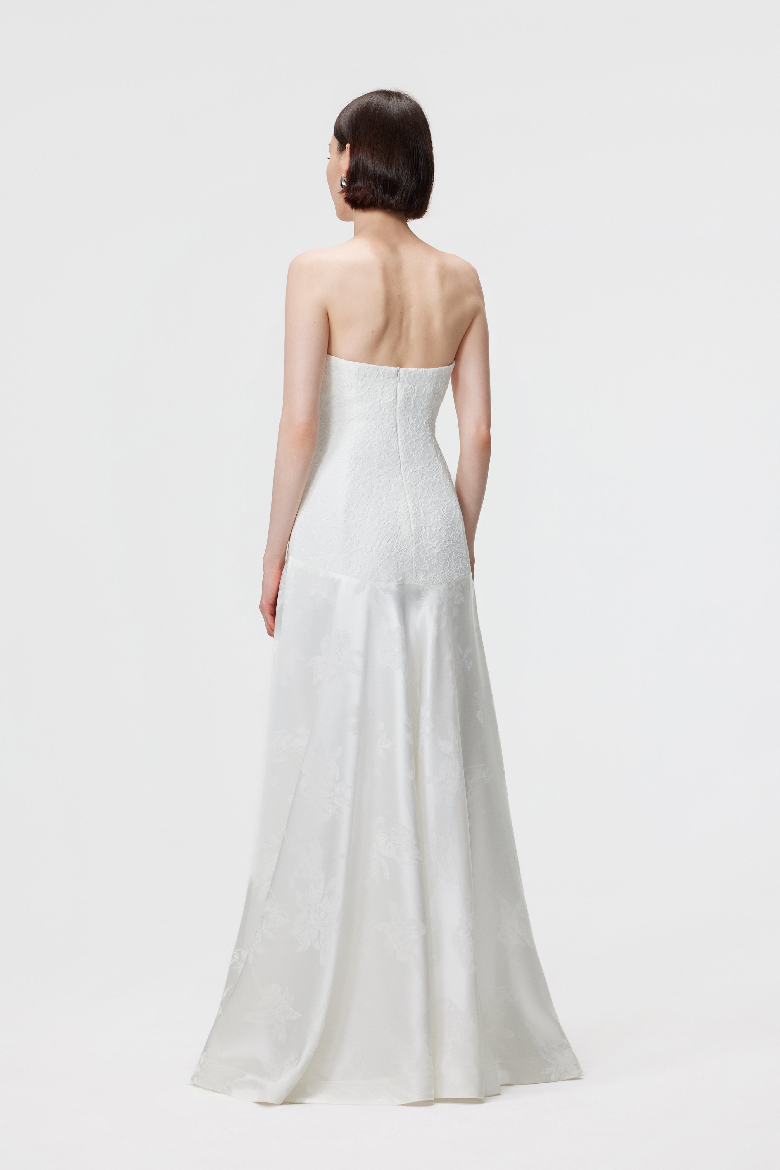 Back view of the Vera Gown in Pearl white showing the seamless invisible center-back zip closure and the elegant, clean lines of the architectural bias-cut skirt.