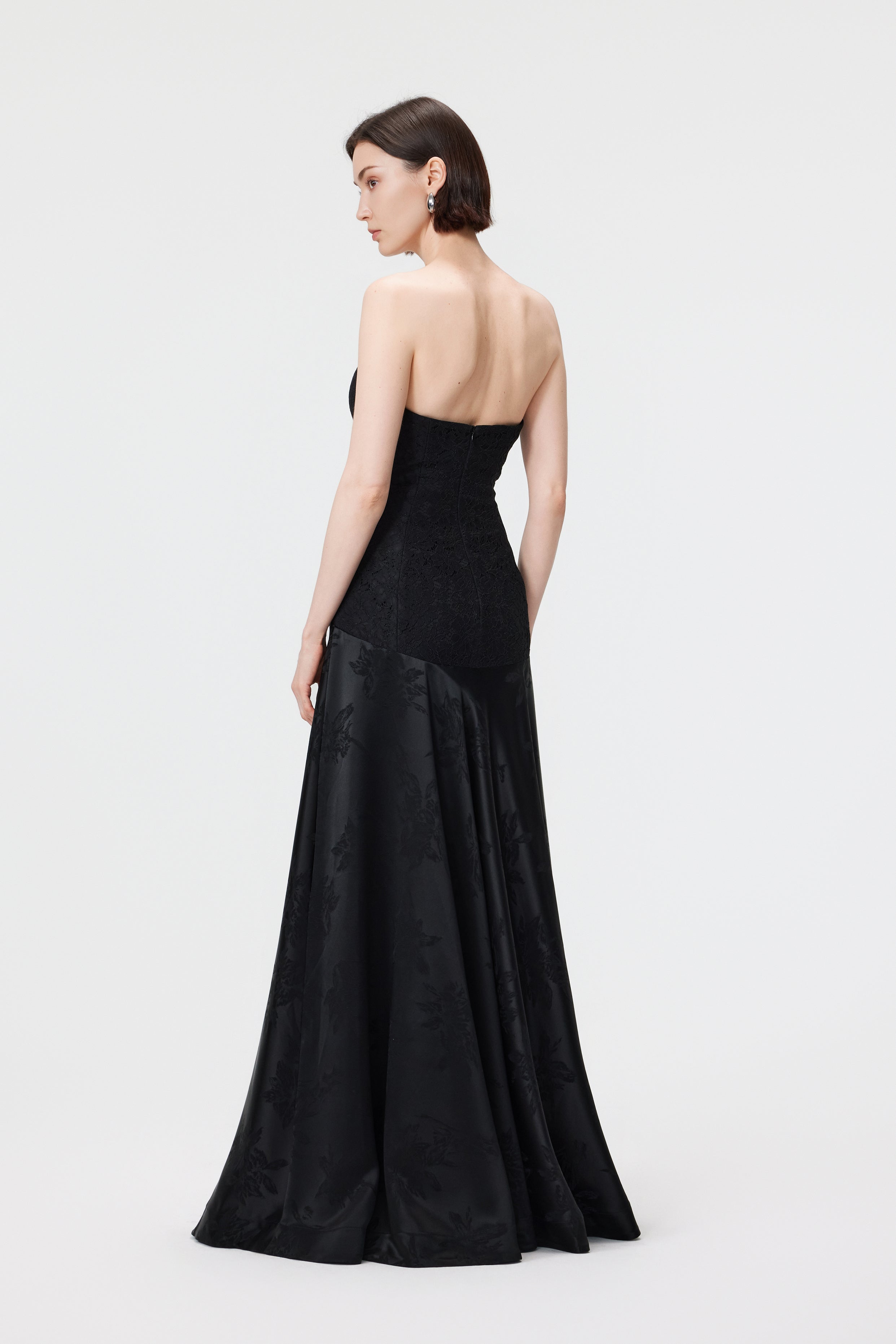 Back view of the Vera Jacquard gown in Black, showing the delicate straps, invisible zipper closure, and a dramatic flared floor-length train.