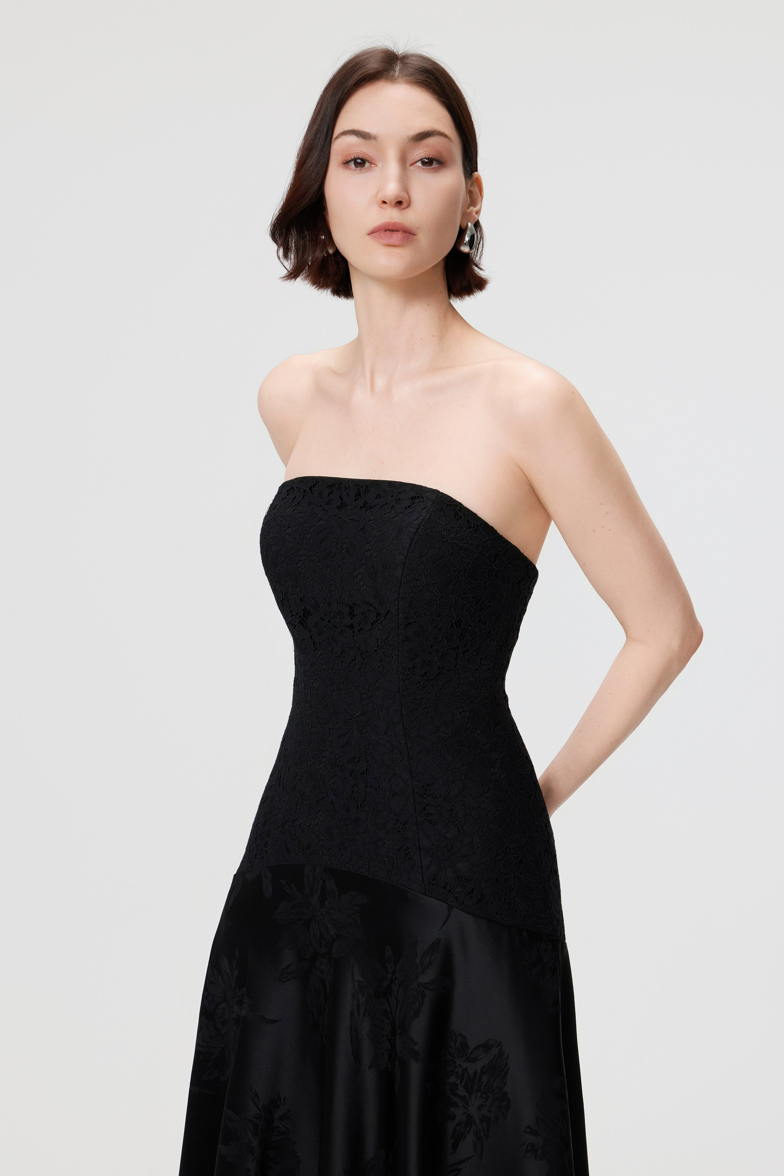 Macro view of the precision-paneled bodice and tonal lace detailing on the Vera gown in Black, reflecting the brand's commitment to artisanal manufacturing.