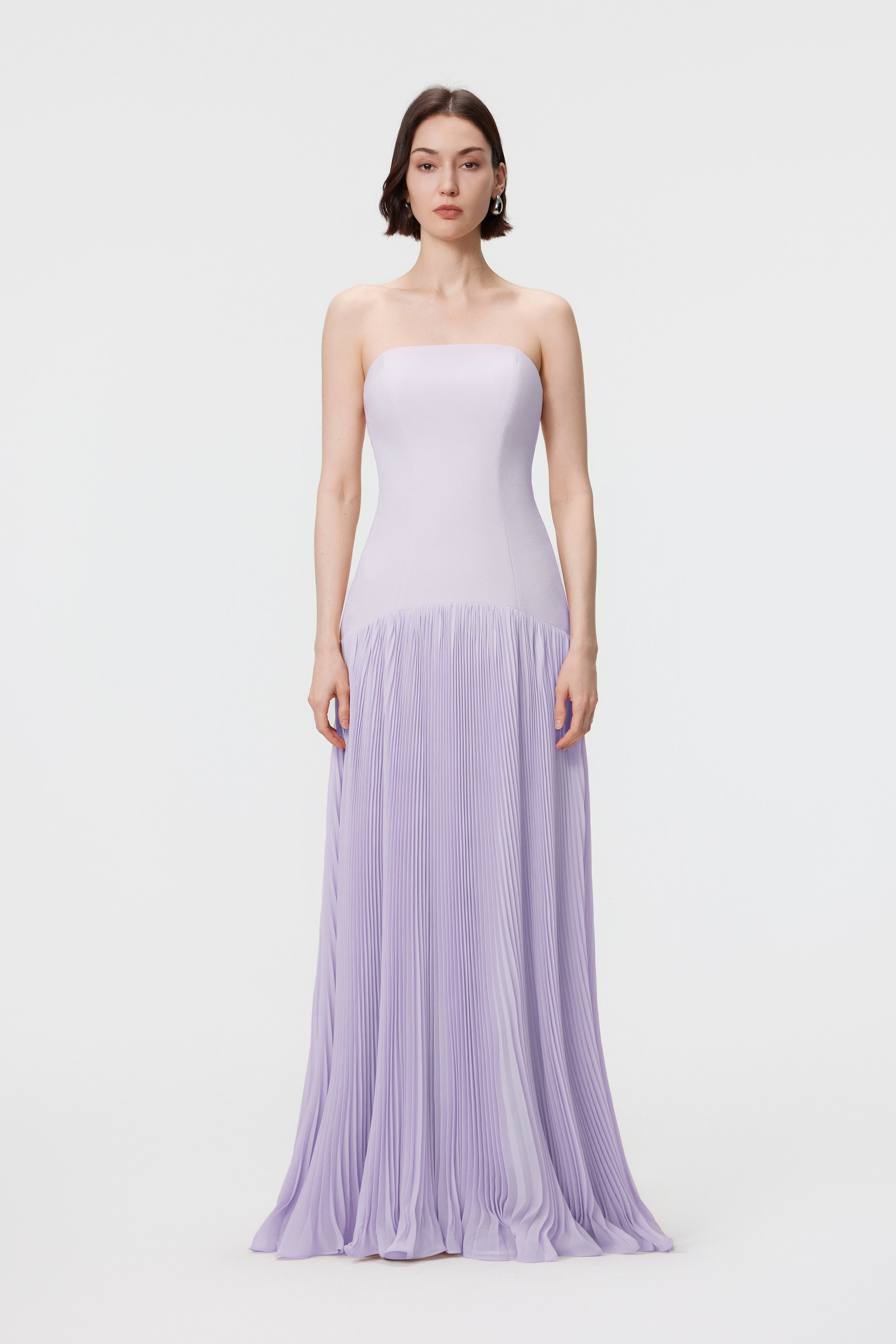 Front view of the AENSO Luna gown in Cloudy Lilac; a statuesque silhouette featuring a structured bustier bodice and voluminous sunray pleats in sustainable slubbed Naia™ acetate.