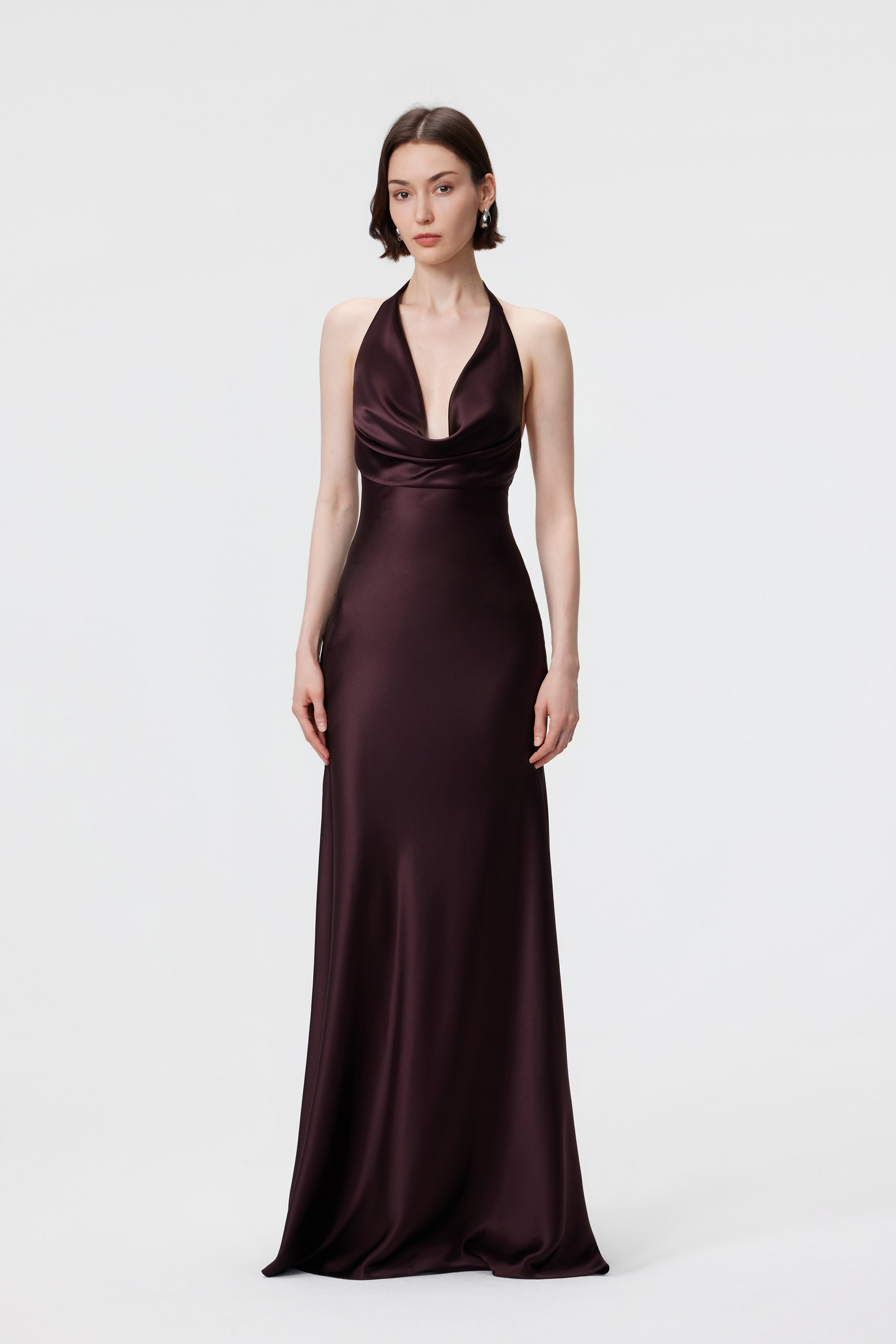 The AENSO Rhea Gown in Espresso; an effortless halter silhouette featuring a draped cowl neckline and silk-like luster.