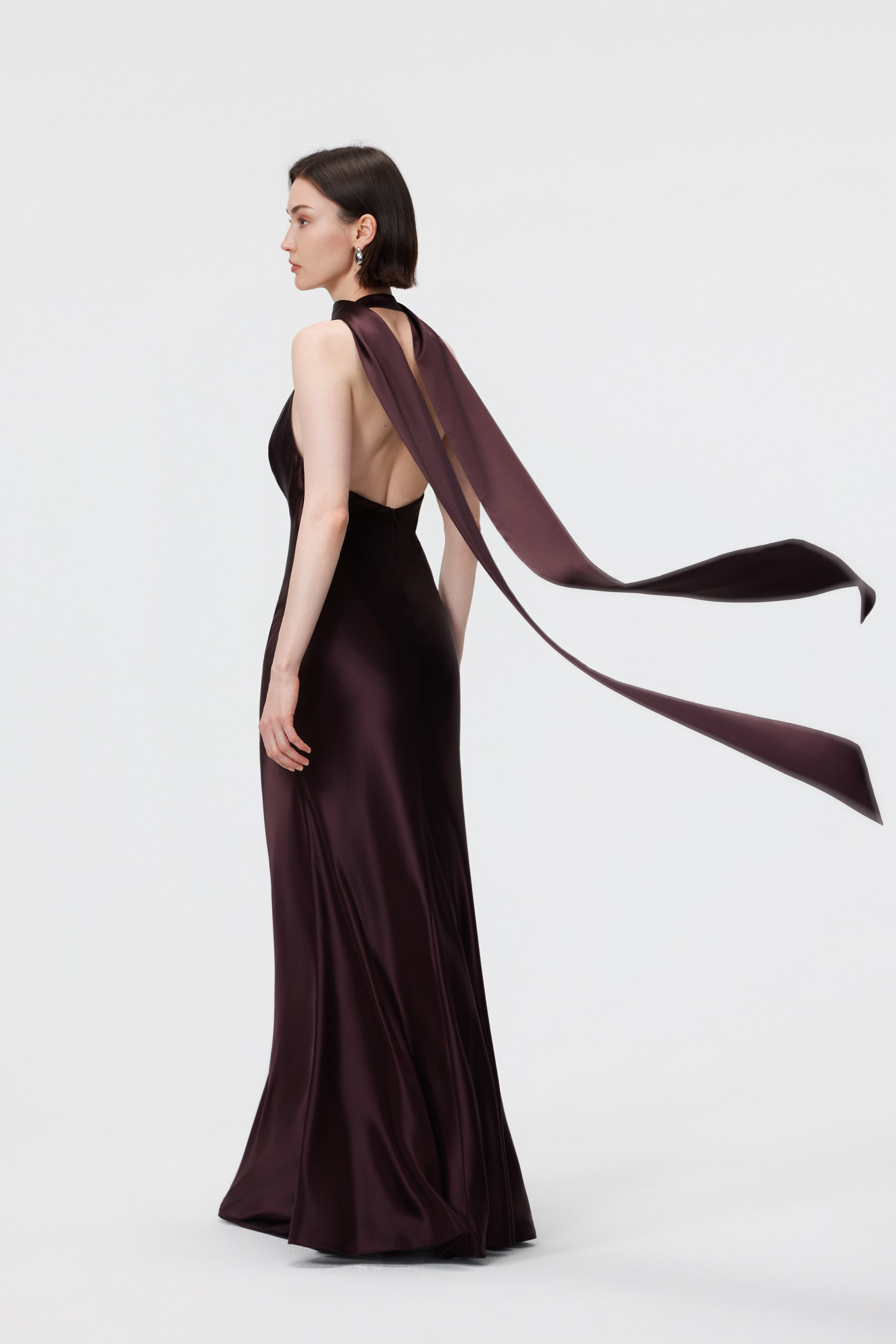 Rear view of the Rhea Halter Gown in Espresso styled with the signature scarf, highlighting the sophisticated open-back and elegant neckline tie.