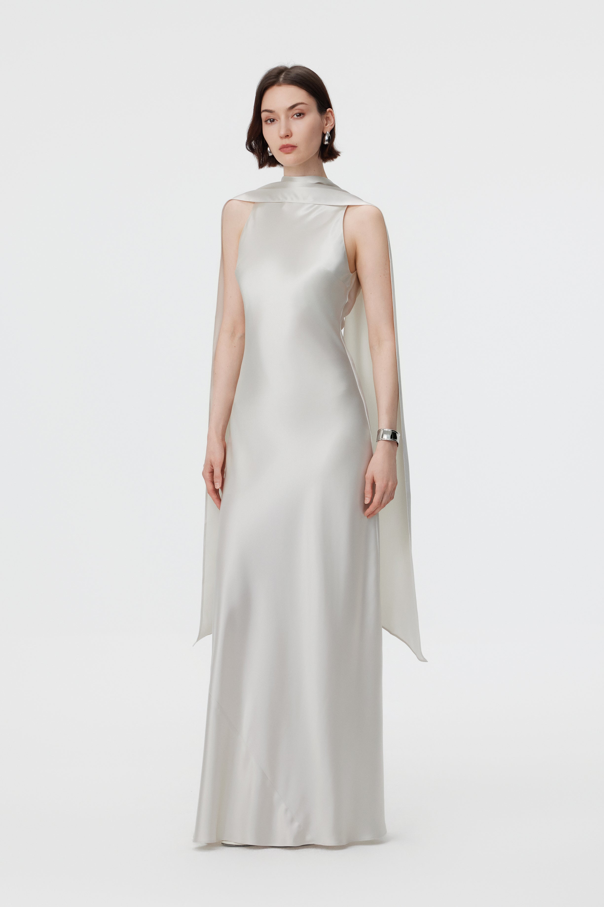 Full-length front view of the AENSO Elara gown in Pearl; showcasing the commanding high-neck profile and the effortless, statuesque flow of the high-volume silhouette in lustrous Naia™ Acetate.
