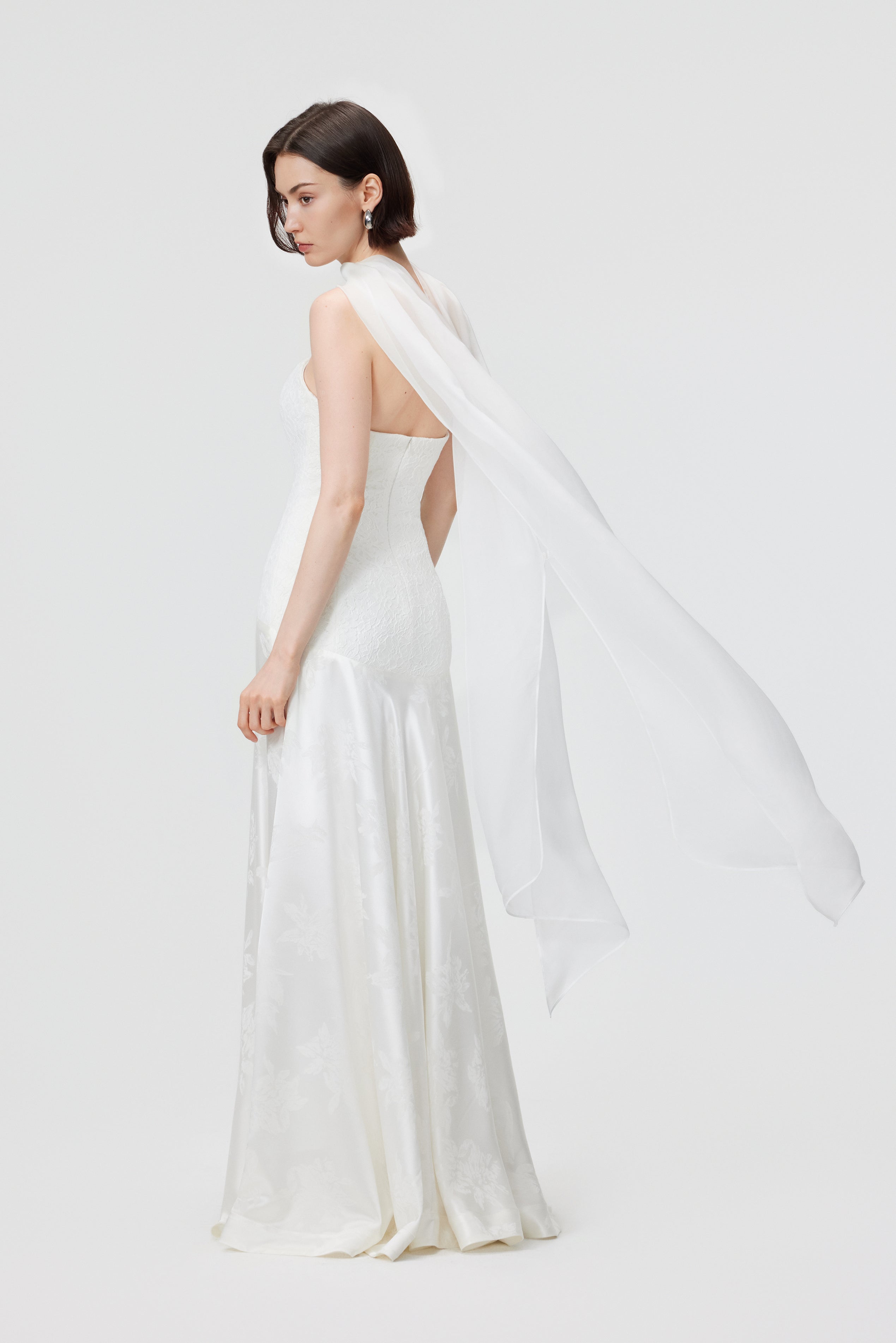 The Vera Gown in motion, highlighting the weighted, liquid drape of the Naia™ acetate floral jacquard skirt and the statuesque flared silhouette from the hips.