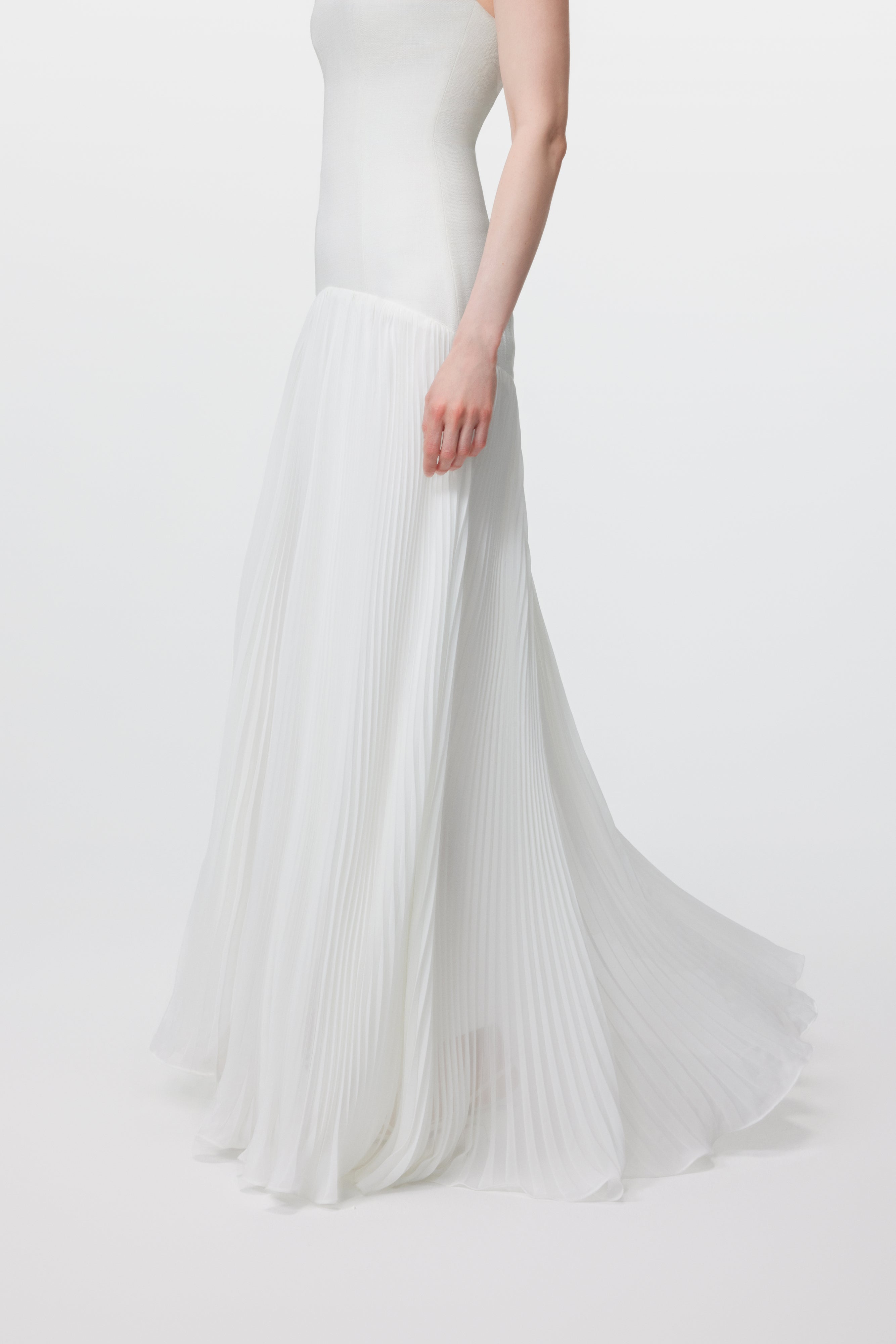 Close-up of the voluminous sunray pleats on the Luna gown, demonstrating the precision of the rhythmic architecture and the lightweight, ethereal movement of the fabric.