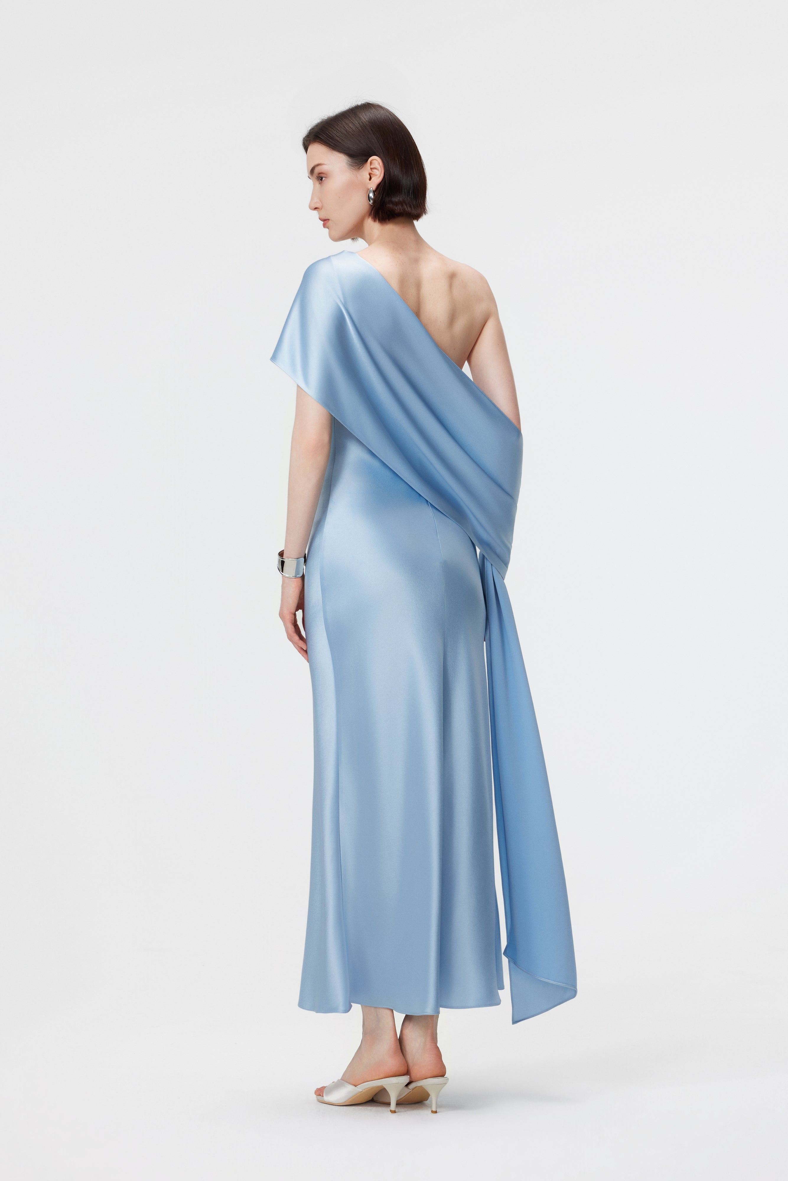 Rear view of the Lyra dress in Glacial Mist; highlighting the precision bias-cut fit and the elegant flow of the hand-held scarf.