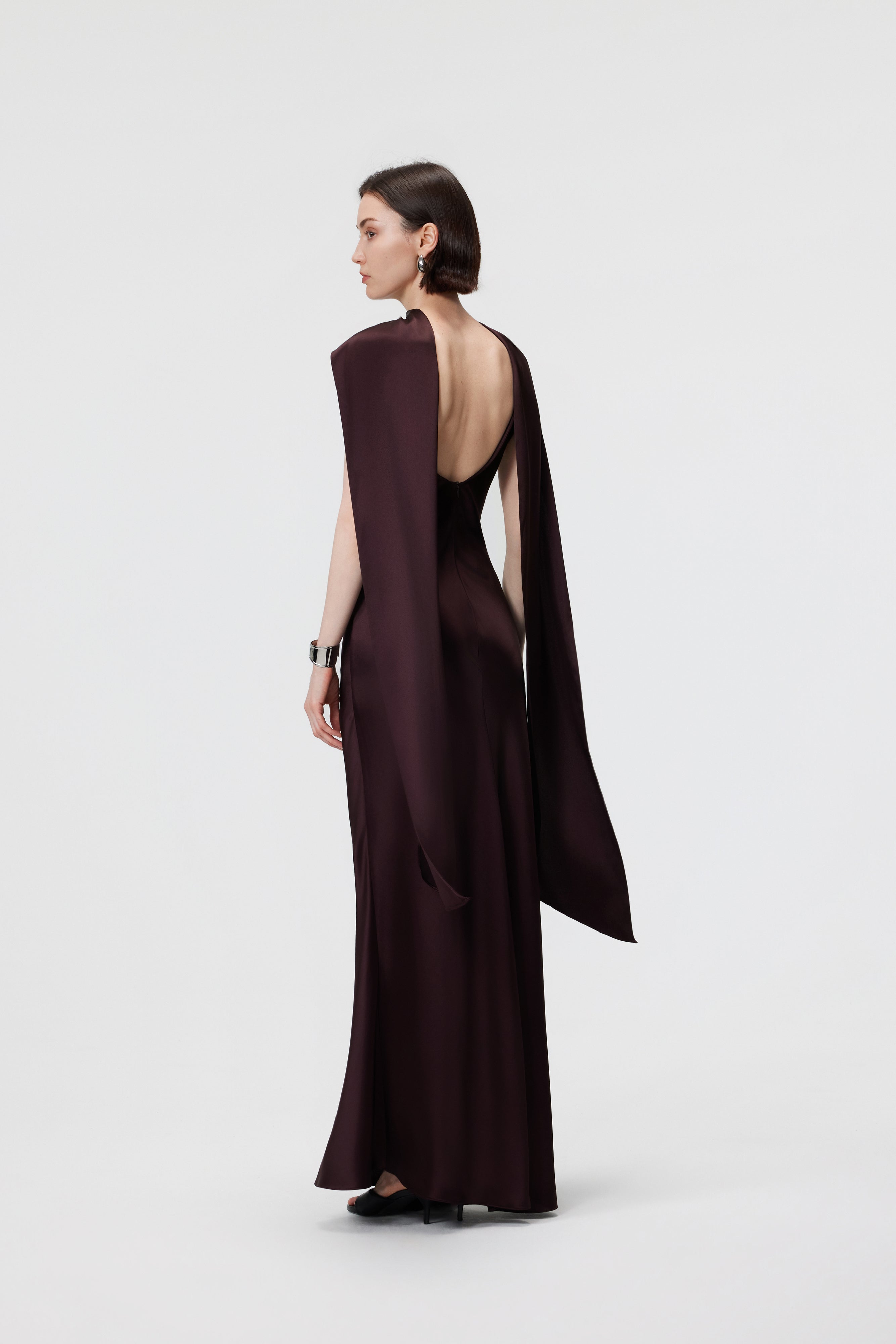 Rear view of the AENSO Elara Gown in Espresso, highlighting the refined open-back detail and the seamless flow of the bias-cut Naia™ Acetate.